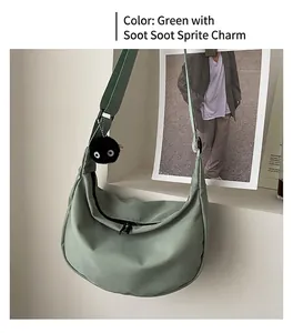 Detail of light green nylon hobo bag with a cute black soot sprite plush pendant