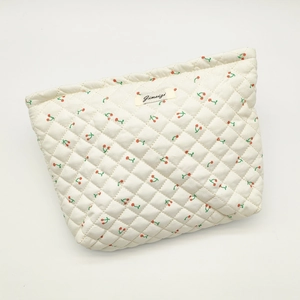Quilted cotton makeup bag featuring red cherry prints and Jimena brand woven label