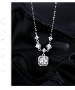 Macro shot of 1 carat moissanite halo square pendant on S925 silver necklace on black leather