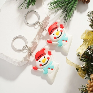 Cute Christmas snowman keychains with red hats and blue scarves on a white stone base