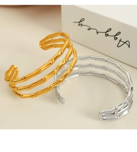Close-up of gold and silver open bangles with elegant bamboo texture design