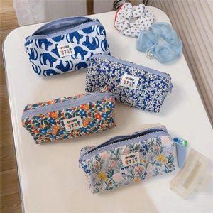 Detailed top view of four floral canvas pouches with zipper closure and cute embroidery labels
