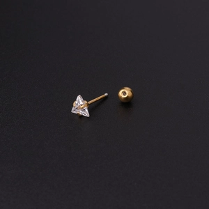 Gros plan d'un clou d'oreille triangulaire en zircon doré avec fermoir à bille vissée