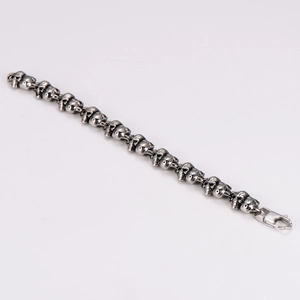 Detailed macro view of vintage stainless steel skull link bracelet with lobster clasp