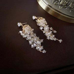 Boucles d'oreilles pendantes dorées avec longs glands en zircon et design en cristal