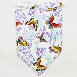 Detail of white pet bandana featuring vibrant butterfly and floral prints with yellow stitching