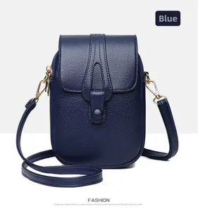 Detail of blue litchi grain leather crossbody phone bag with gold zipper and magnetic closure