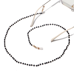 Detail of black beaded eyewear chain with golden clasps and silicone loops