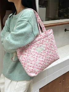 Detail of pink floral quilted cotton tote bag with Sarakka Studio woven label on surface