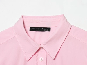 Close-up of pink poplin shirt collar with woven texture and size label detail