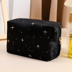 Detailed view of the gold star embroidery on high-quality black velvet makeup bag