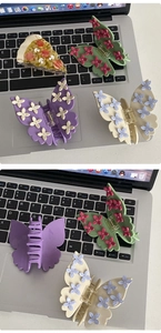 Detail of butterfly hair claws with floral accents and rhinestones on a keyboard