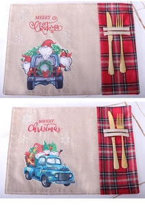 Close-up of linen Christmas placemats with gnome patterns and plaid cutlery pocket