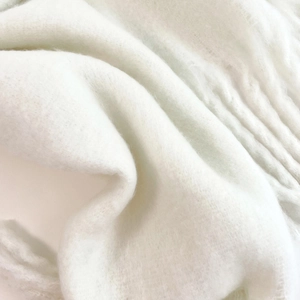 Macro view of white mohair scarf texture showing soft, fluffy fibers and plush material