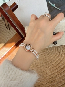 Detailed macro view of an elegant rose gold shell dial watch with luxury pearl strap