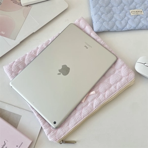 Détail de la housse iPad rose matelassée à cœurs avec nœud et fermeture éclair en métal