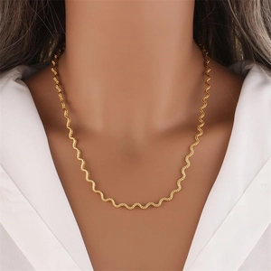 Elegant gold wave spiral chain necklace for women worn on a white V-neck top