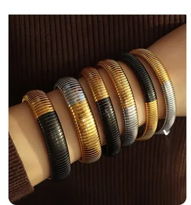 Detail of three-tone gas pipe elastic bracelets in gold, silver and black on wrist