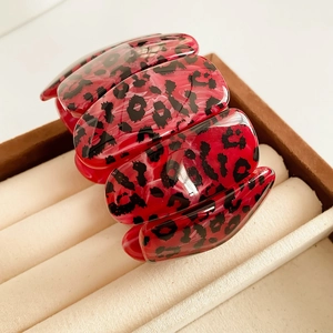 Détails de l'imprimé léopard rouge sur les maillons en résine du bracelet extensible