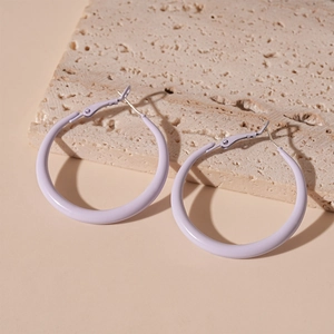 Detail of minimalist lilac purple matte hoop earring on a beige travertine stone