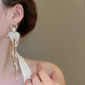 Detail of floral tassel earrings with pearls and rhinestones on model's ear