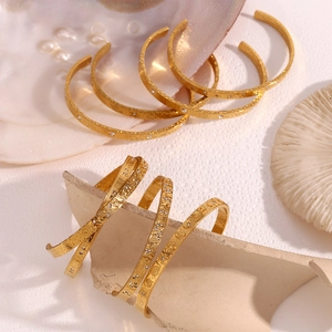Detailed close-up of 18K gold-plated ocean style bangles with texture and small crystals