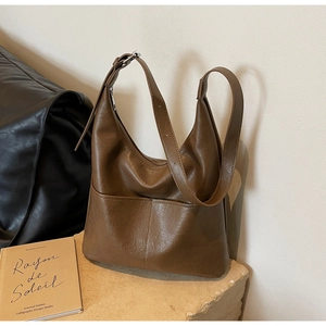 Detailed view of retro brown leather bucket bag with stitching and front pocket