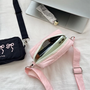 Detailansicht der gesteppten Umhängetaschen in Pink und Schwarz mit geräumigem Innenfach