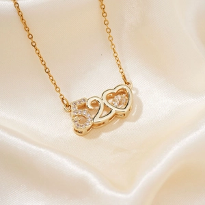 Gold minimalist 520 heart necklace with white zircon on beige satin background