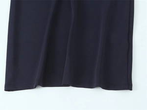 Vue détaillée du tissu bleu marine avec finitions de couture précises sur l'ourlet