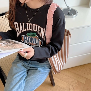 Detail of a casual black crewneck sweatshirt with retro BALIQUEN lettering and soft cotton texture