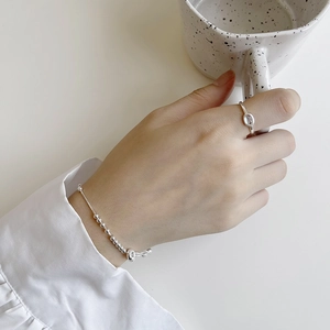 Elegant S925 sterling silver beaded bracelet and gemstone ring worn in a tea scene