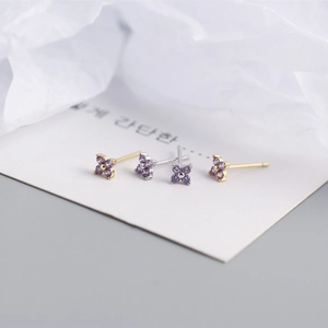 Macro shot of S925 silver four-leaf flower stud earrings with purple marquise zirconias