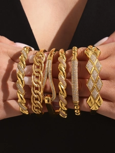 Dettaglio di lussuosi bracciali in acciaio inossidabile placcati oro 18k con zirconi