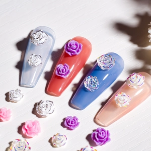 3D resin rose nail art charms in white and pink on colorful manicure tips