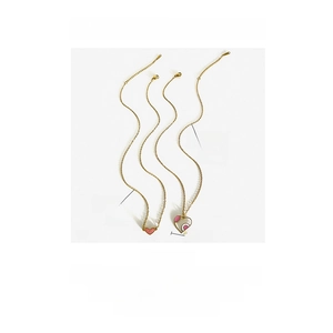 Detail view of heart pendant necklaces with gold plating and pink enamel inlay