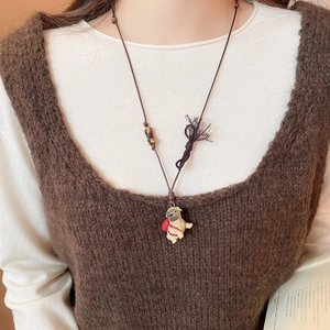 Detail of cute Pug ceramic pendant on adjustable brown cord with stone bead
