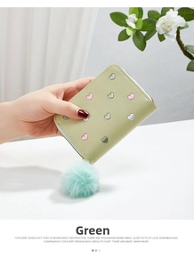 Close-up of light green PU leather wallet with heart embroidery and plush pom-pom charm