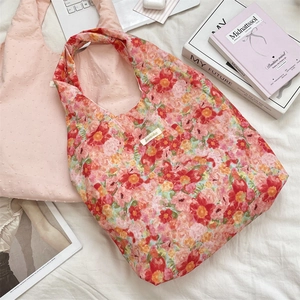 Detail of floral and polka dot tote bags on a white fabric background with accessories