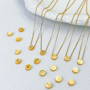 Vista dettagliata di vari ciondoli emoji dorati con motivi di smiley, cuore e stella