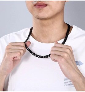 Close-up of a trendy black polished stainless steel flat Cuban link necklace for men