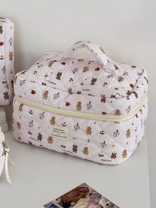Détail de la trousse de maquillage rose matelassée avec motifs ours et poignée
