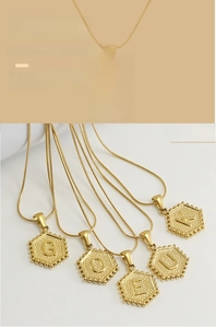 Détail de pendentifs alphabet hexagonaux plaqués or 18 carats avec lettres en relief