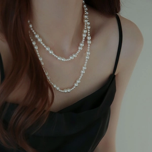 Gros plan d'un collier de perles à deux rangs montrant des perles très brillantes