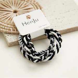 Detail of black and white braided hair ties on a textured background with display card
