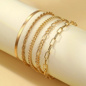 Detail of bohemian gold-layered chain bracelet set showing snake and curb link styles