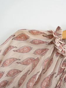 Detailed macro view of apricot chiffon shirt with paisley print and gold metallic threads
