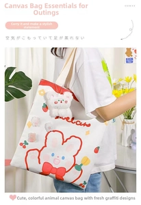 Detail of cute canvas tote bag featuring cartoon bunny print and plush bear charm