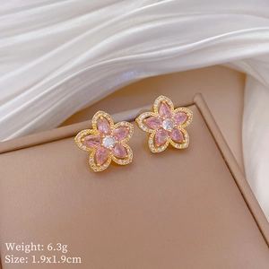 Detail of pink crystal flower earrings with gold base on a jewelry box and silk cloth