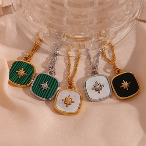 Detail of square starburst pendants with green, white, and black shells on silk